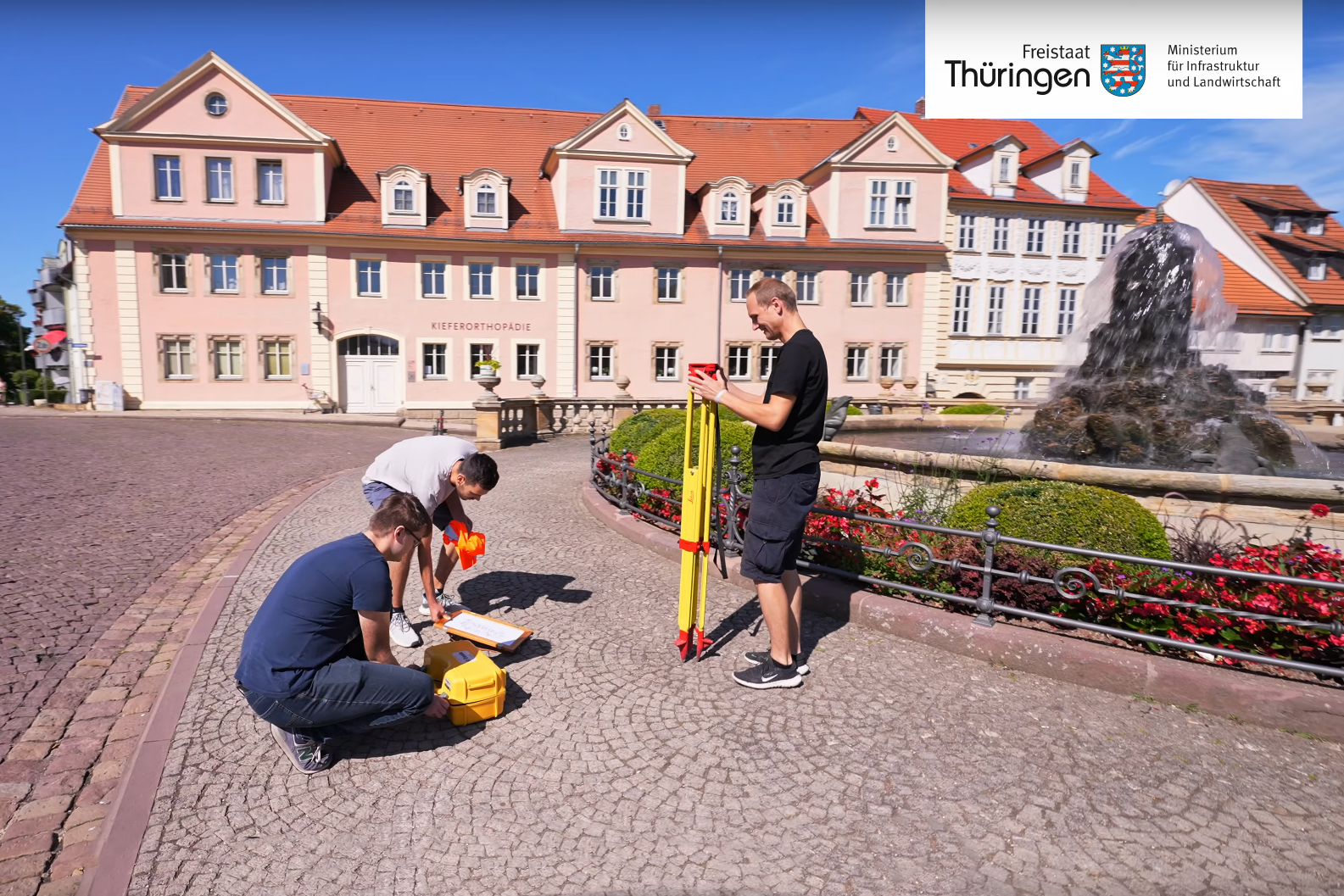 Ausbilder und Auszubildende des TLBG bauen eine Vermessungsstation auf in Gotha vor dem Schloßberg 1, über der Wasserkunst