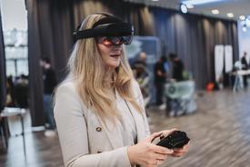 Die Staatssekretärin im Portrait mit Hololens auf dem Kopf und Controller in der Hand zum navigieren.