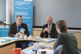 Der TTG-Geschäftsführer und der Präsident des TLBG erläutern einer jungen Redakteurin die Besonderheiten der neuen Radkarte.