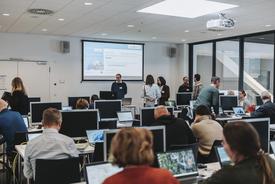 Reger Austausch vieler Workshop-Teilnehmer an ihrem PC-Arbeitsplätzen vor Beginn eines Workshops.