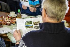 Ein älterer Mann liest sich den Flyer zum Verfahren durch.