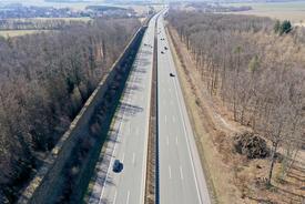 Luftaufnahme einer Autobahn im Herbst mit kahlen Wäldern