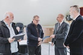 Uwe Köhler (TLBG) übergibt die Schlussfeststellung an TG-Vorsitzenden Wilfried Höfer. Herr Heineck (Bürgermeister Schwallungen) und Steffen Schütz (TMDI) schauen zu.