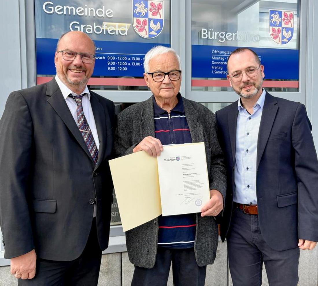 Herr Floßmann hält seine Ehrenurkunde in den Händen. Neben ihm stehen Präsident Köhler (TLBG) und Bürgermeister Christian Seeber