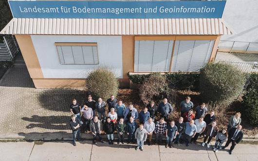 Drohnenfoto der Tagungsteilnehmer:innen vor dem Haupteingang des TLBG. Rechts außen steht Präsident Uwe Köhler.