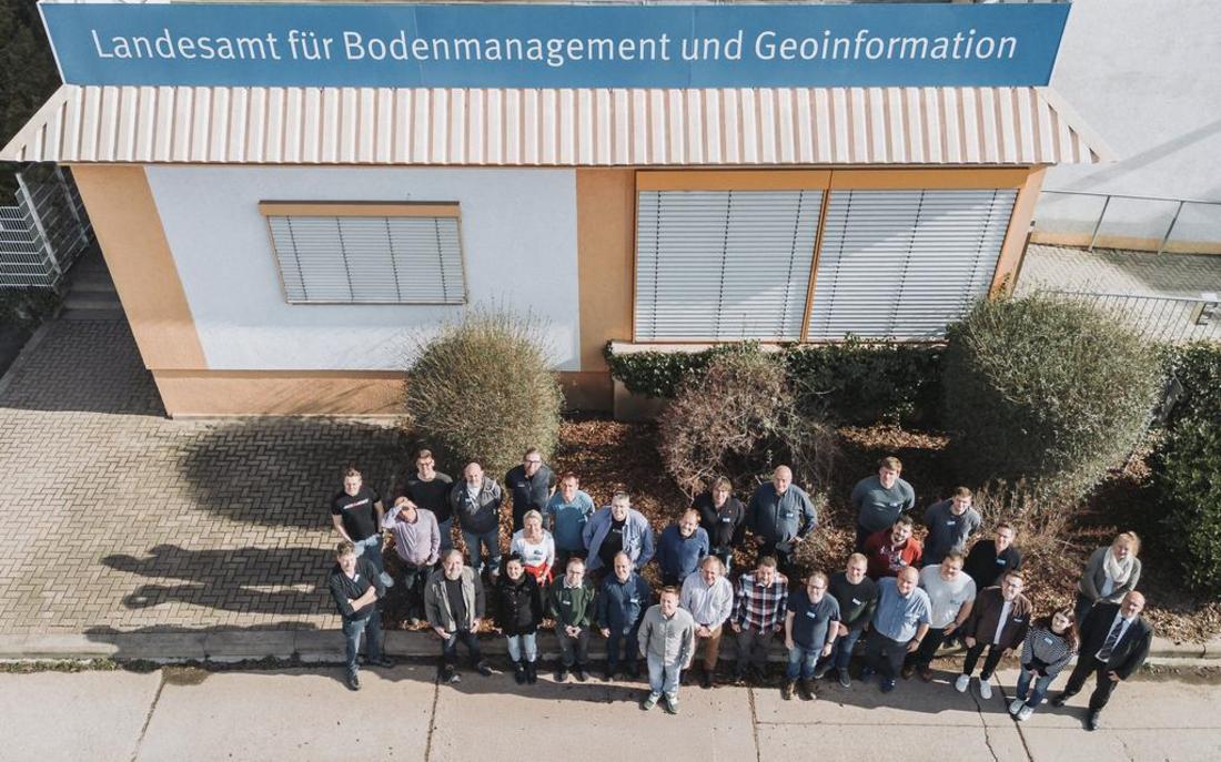 Drohnenfoto der Tagungsteilnehmer:innen vor dem Haupteingang des TLBG. Rechts außen steht Präsident Uwe Köhler.