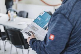 Blick über eine Schulter auf den zum Abschluss des Flurbereinigungsverfahrens angefertigten Flyer.
