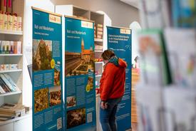 Eine interessierte Besucherin beim Betrachten eines Roll-ups zu den beiden vorgestellten Eichsfeld-Wanderkarten