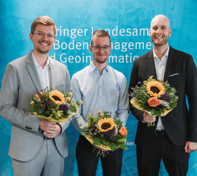 Foto der drei Assesoren mit Blumenstrauß
