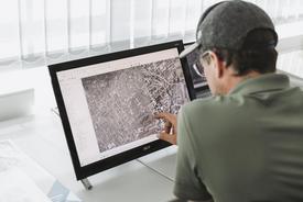 Blick über die Schulter eines Mannes am Laptop sitzend. Demonstriert wird ein Luftbild-Projekt