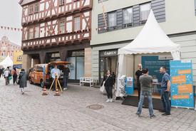 Foto von unserem Stand auf der Jobmeile am Brühl mit Azubis vom Messbus und Standpersonal vor einem Zelt mit digitalen und analogen Angeboten.