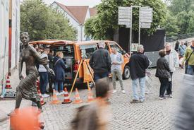 Messbus vor der Liegenschaft mit interessierten Besuchern am Stand und sich vorbeibewegenden Publikumsverkehr